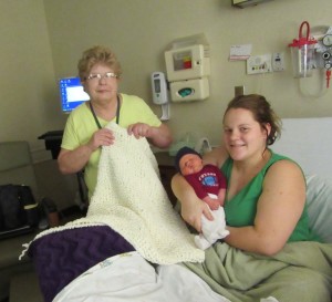 Anita Greene gives a hand-knitted blanket to Alyssa Pooler, and her baby boy, Bentley, at Wayne HealthCare Special Beginnings.